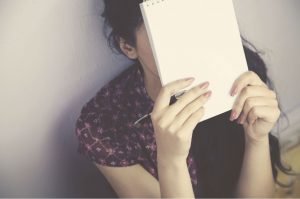 mujer cubre cara zero zum cuaderno escribir triste bajar tu autoestima