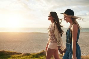 dos 2 amigas mujeres atardecer amistad hablando-playa ser feliz sale terminó